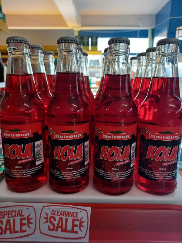 A red coloured drink called Kola in a glass bottle.